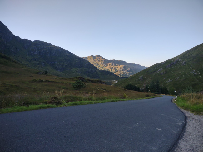 Photo of road running through hills in scotland